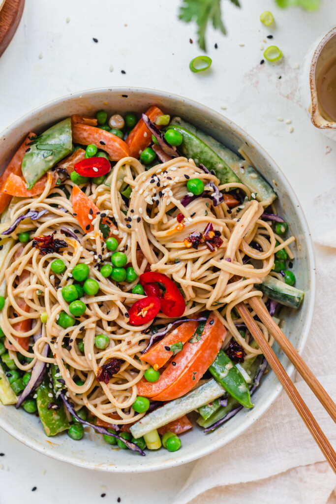 Close up of noodles with tahini sauce and vegetables