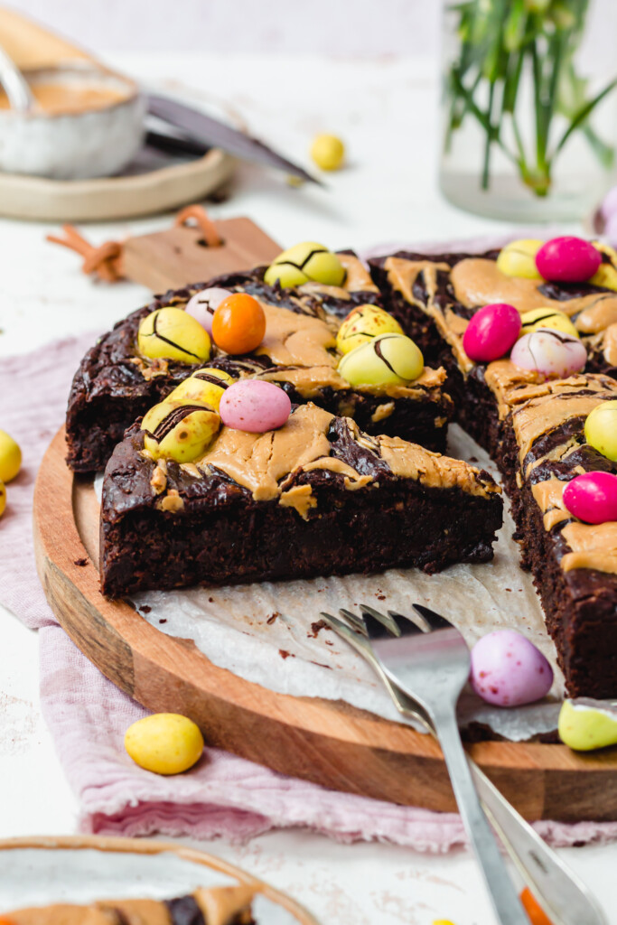 Mini Egg Peanut Butter Flourless Brownies on a wooden board with two forks
