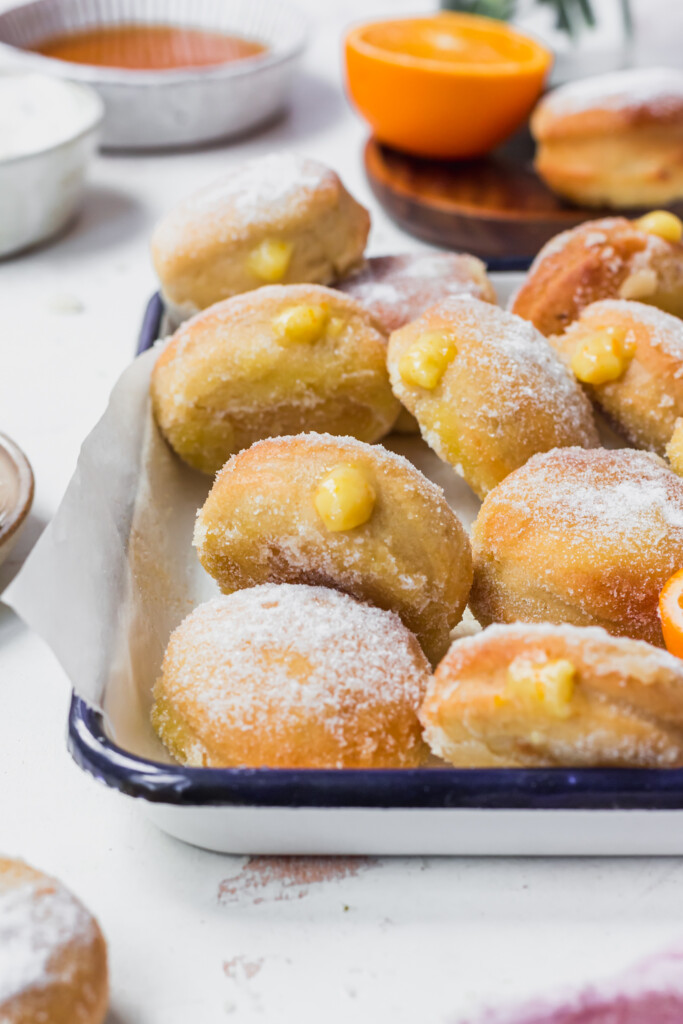 A white dish of Orange Curd Air Fryer Baked Vegan Donuts