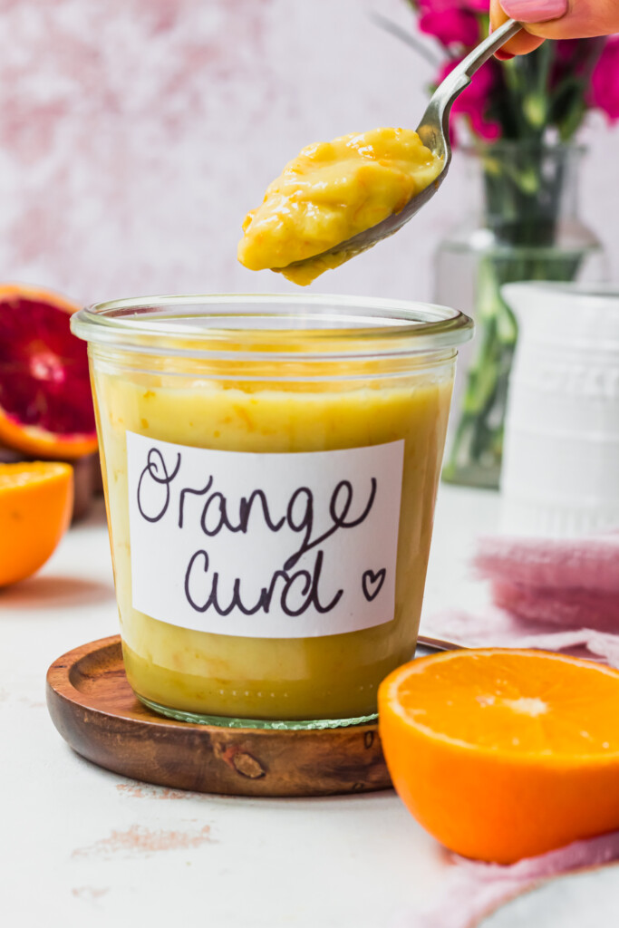 A jar of Vegan Orange Curd and a spoon above it