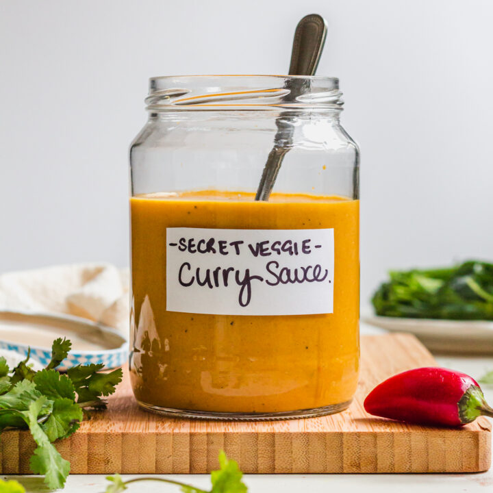 A spoon in a jar of Vegetable Packed Vegan Curry Sauce