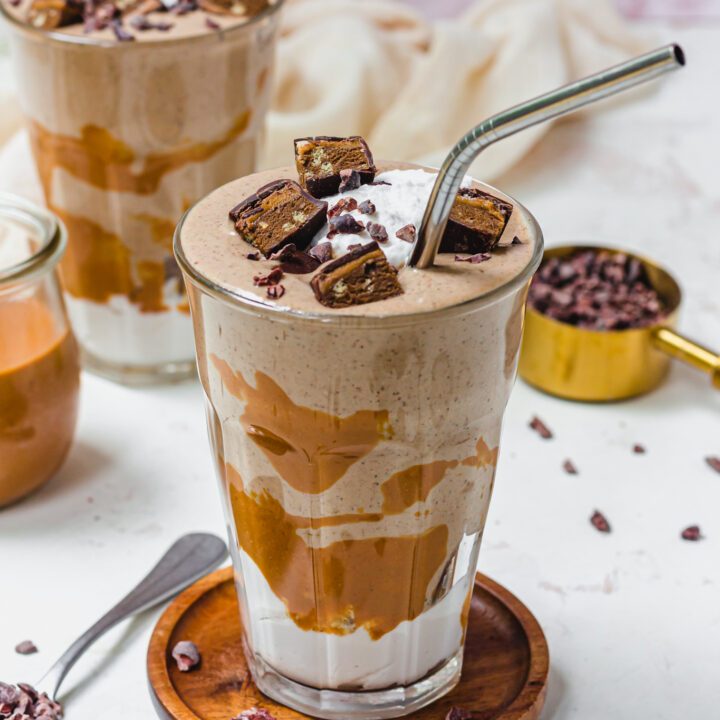 A glass of Peanut Butter Crunch Protein Smoothie with chocolate on top