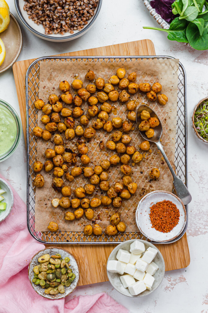 Crispy golden roasted chickpeas on a tray with a spoon