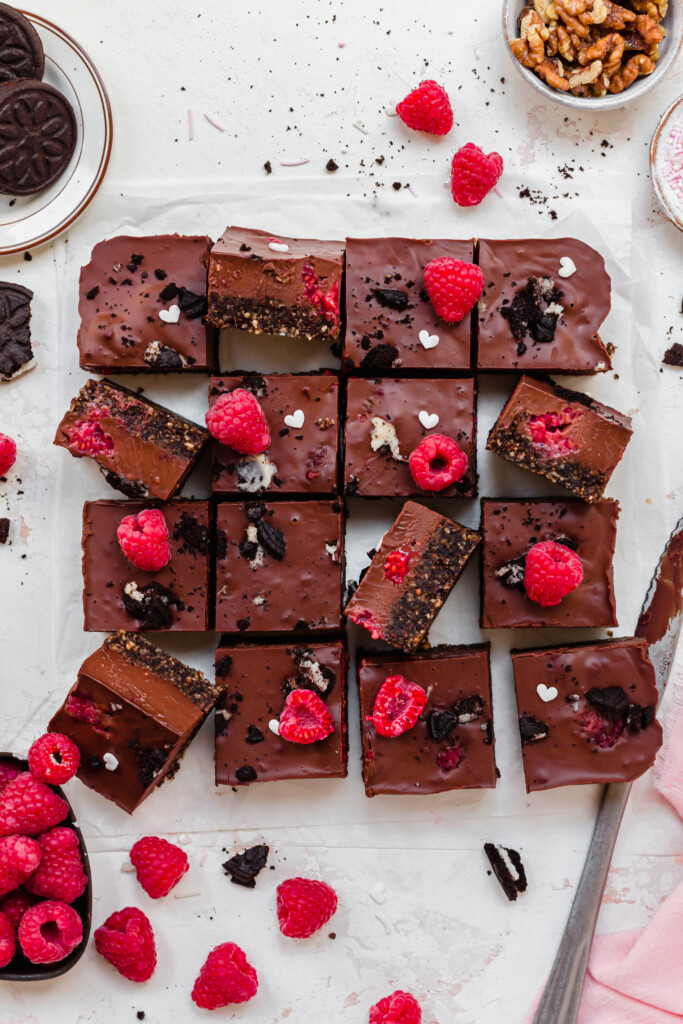 16 squares of No Bake Chocolate Raspberry Ganache Brownies on a white board