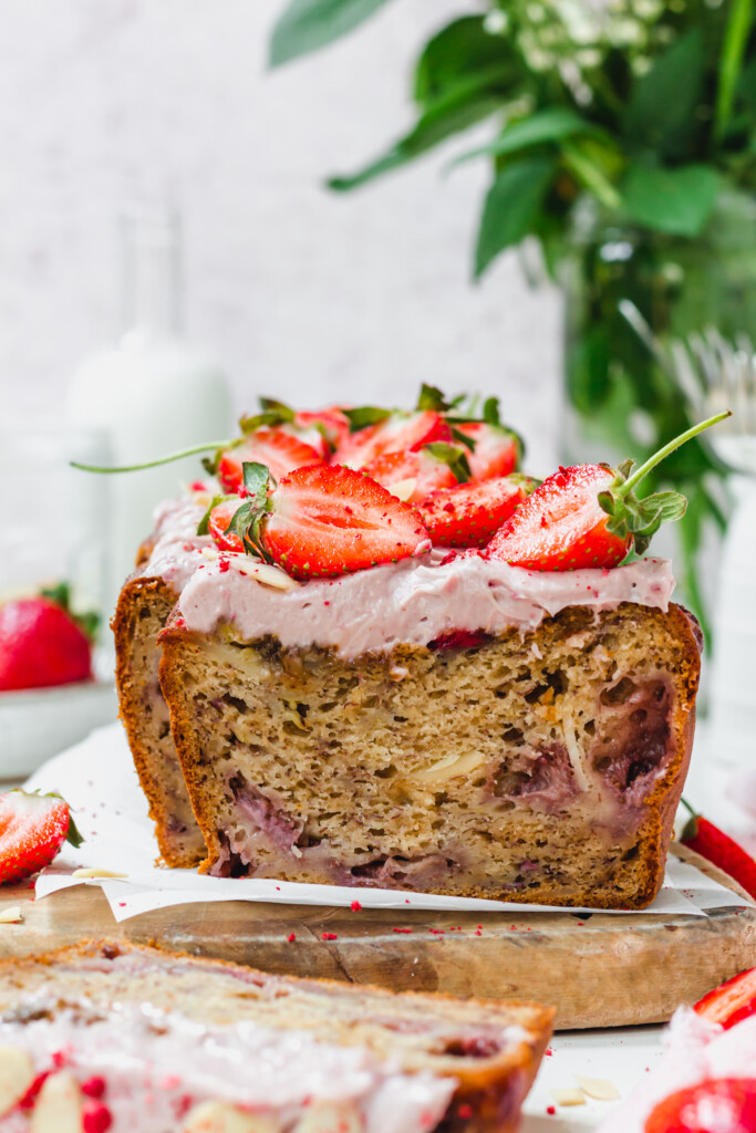 A loaf of Strawberry Almond Banana Bread on a wooden board