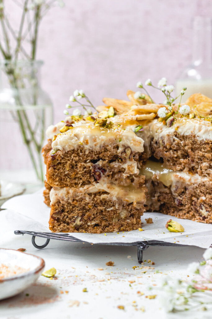 A slice of Vegan Hummingbird Cake in front of the cake with lemon curd filling