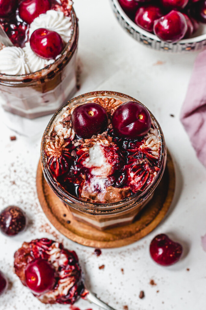 The top of a jar of Black Forest Creamy Oats with cherries and cream