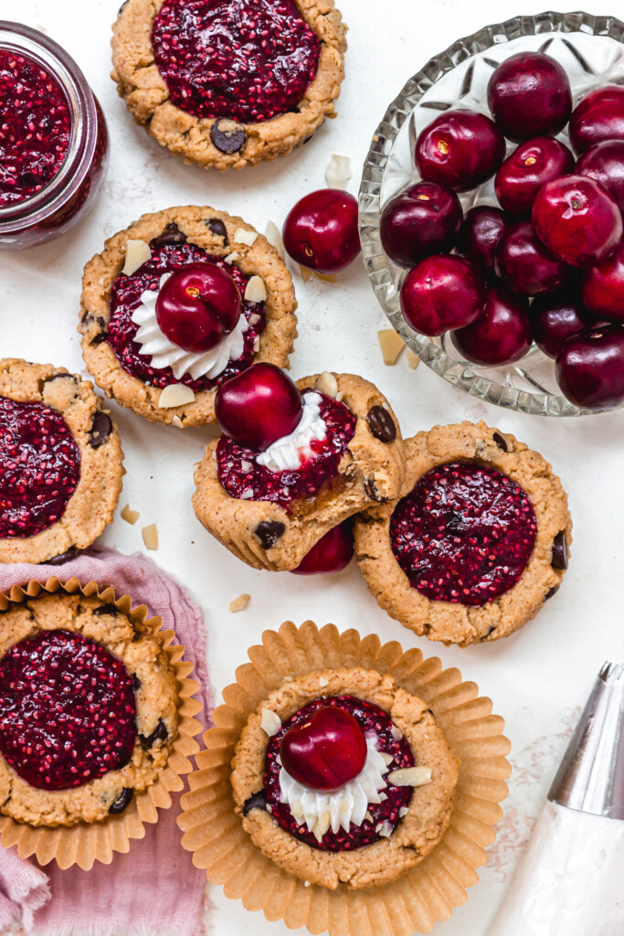 A few Cherry Bakewell Cookie Cups on a white backdrop