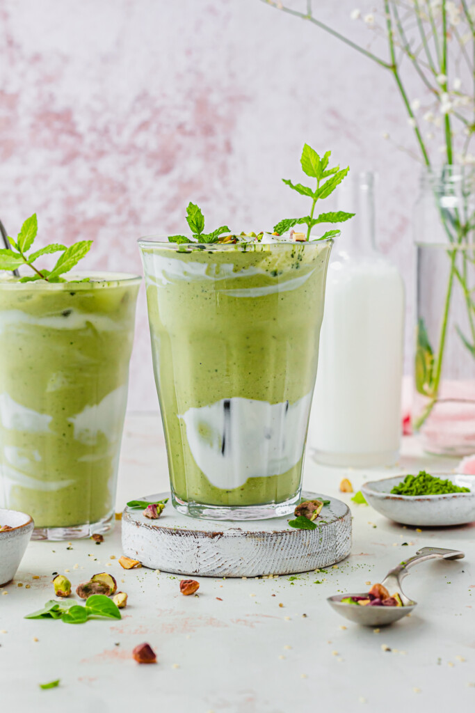 Two glasses of Iced Pistachio Matcha Mint Shake with fresh mint