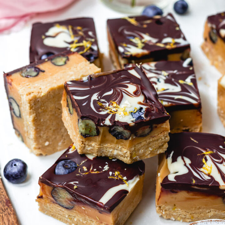 A bitten Lemon and Blueberry Chocolate Caramel Slice on top of other bars