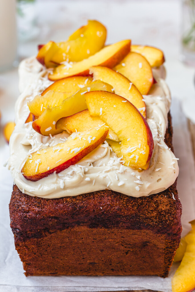 Sliced peaches, yoghurt and coconut on top of banana bread