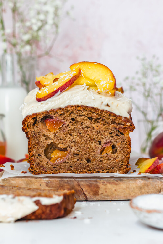 A loaf of Peaches and Cream Banana Bread on a wooden board