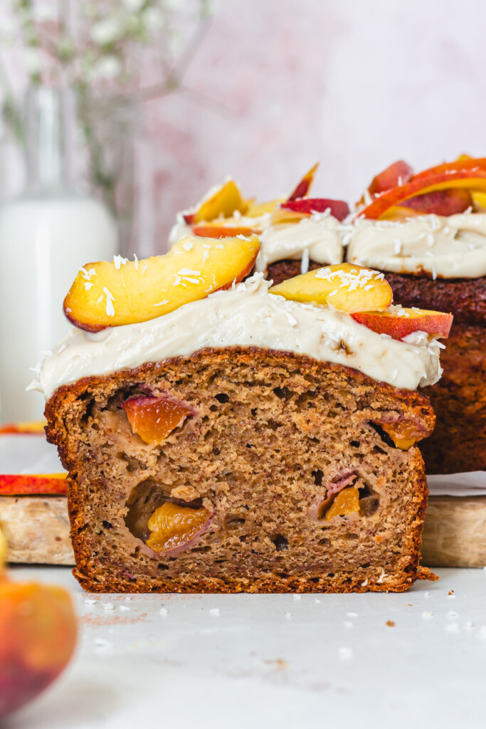 A slice of Peaches and Cream Banana Bread in front of a board