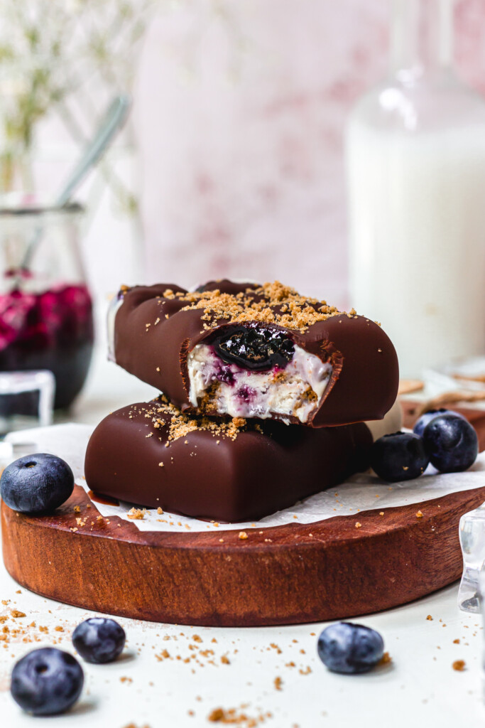 Two Blueberry Cheesecake Magnum Ice Creams with chocolate and cookie crumbs