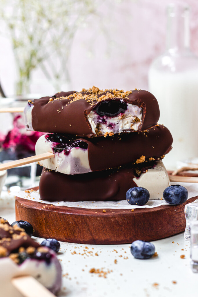 A stack of three Blueberry Cheesecake Magnum Ice Creams with one bitten