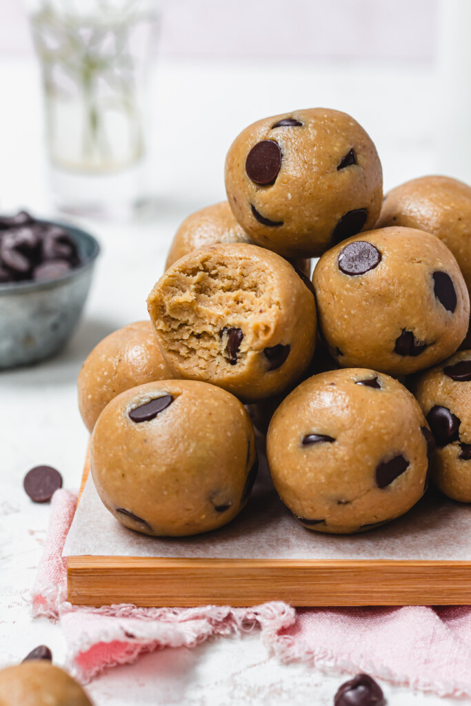 A pile of Healthy Chocolate Chip Cookie Dough Balls on a wooden board