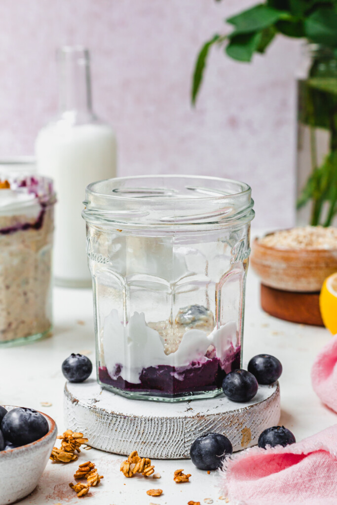 A glass jar with blueberries and yoghurt