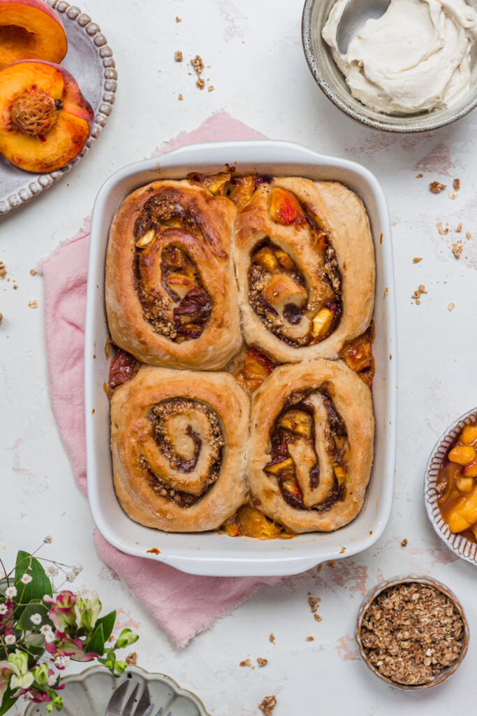 Four Peaches and Cream Cinnamon Rolls in a white dish without frosting