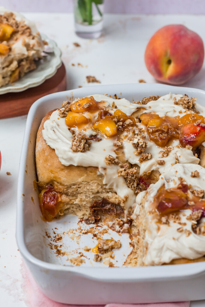Close up of some Peaches and Cream Cinnamon Rolls in a white dish