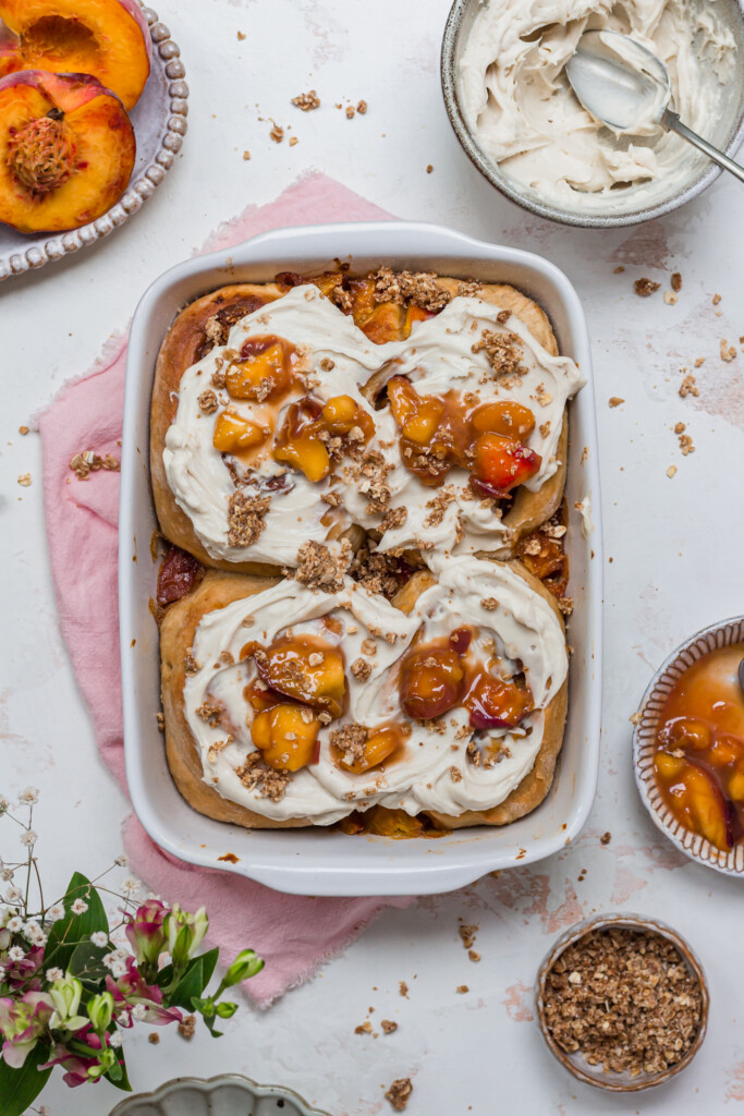 Four Peaches and Cream Cinnamon Rolls in a white baking dish
