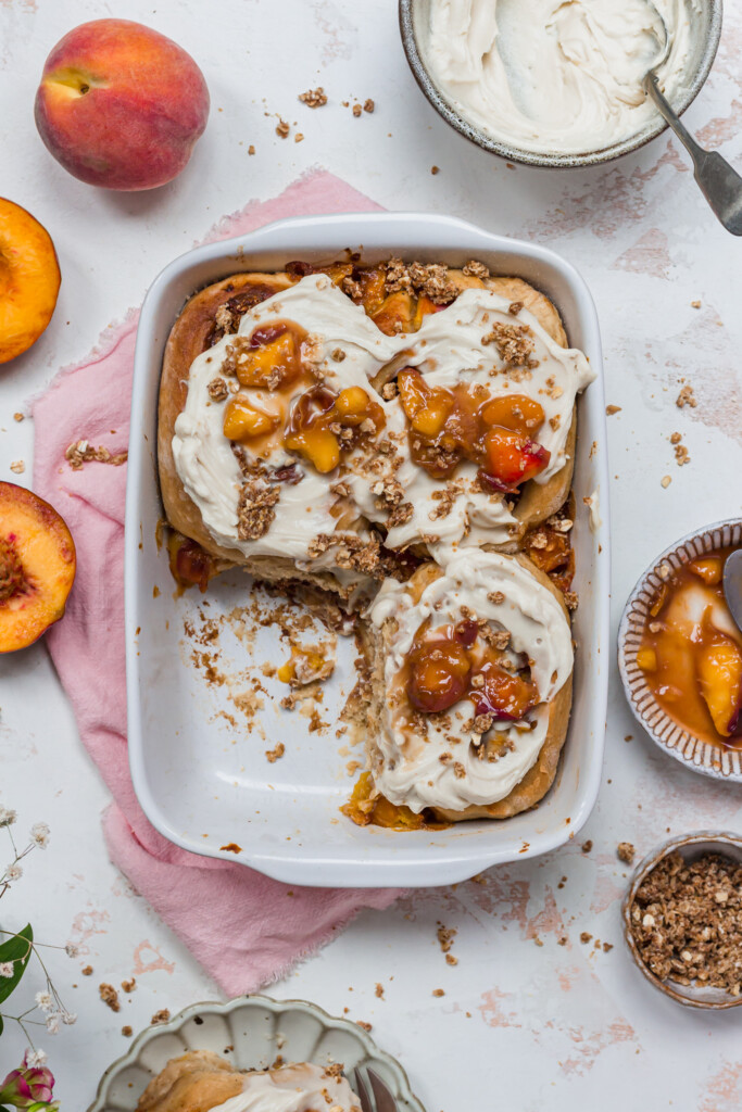 Three Peaches and Cream Cinnamon Rolls in a white baking dish