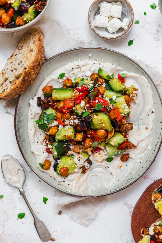A plate of Roasted Aubergine and Chickpea Smashed Cucumbers with Whipped Tahini