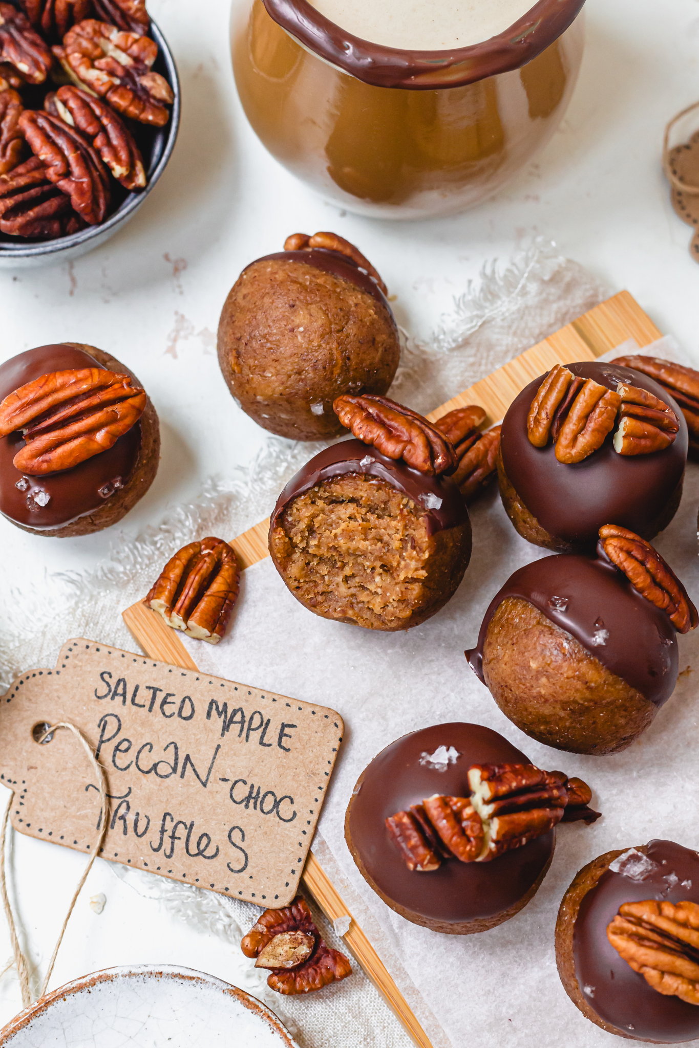 A few Salted Maple Pecan Chocolate Truffles on a board with a label