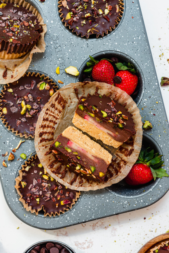 Close up of a chocolate strawberry cup sliced in half on a muffin tray