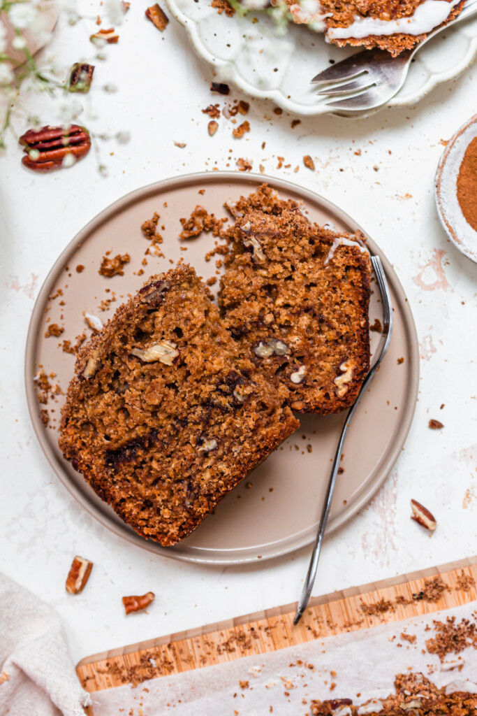 A slice of Apple Pecan Streusel Loaf Cake in half on a plate with a fork