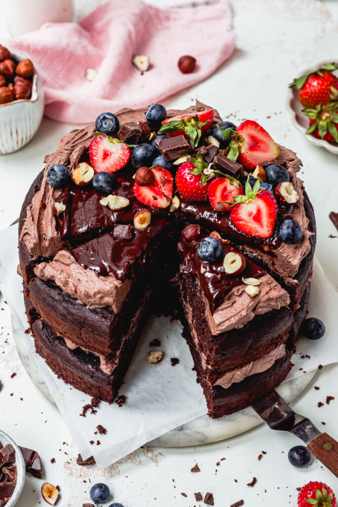 The top of a Chocolate Hazelnut Fudge Cake with berries and ganache