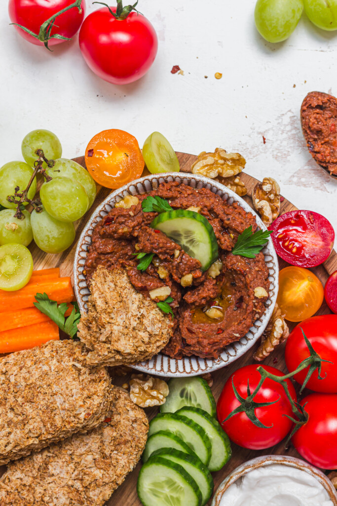 A bowl of Roasted Red Pepper Butterbean Weetabix Dip with cucumber