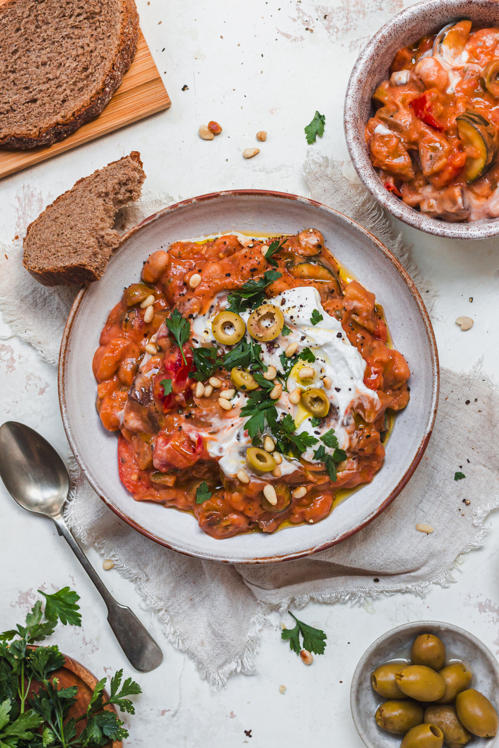 A bowl of Creamy Bean and Aubergine Caponata with a piece of bread