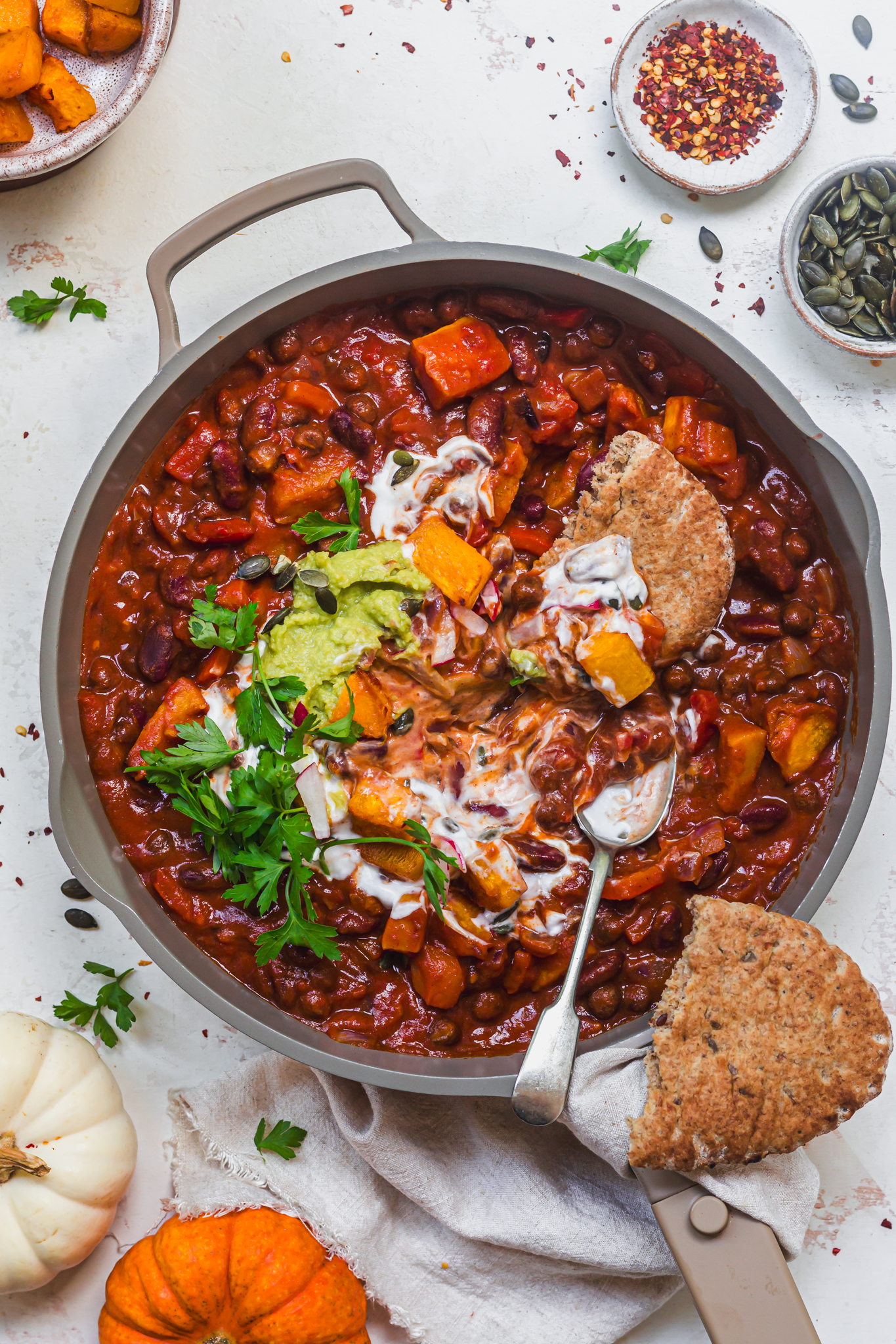 A dish of Roasted Pumpkin and Bean Chilli with flatbreads