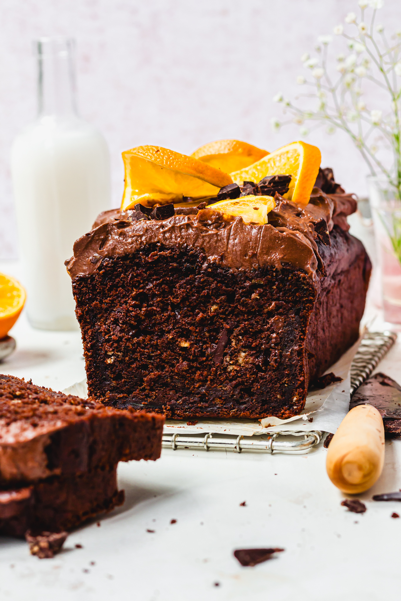 A Double Chocolate Orange Courgette Loaf Cake on a wire rack with a knife