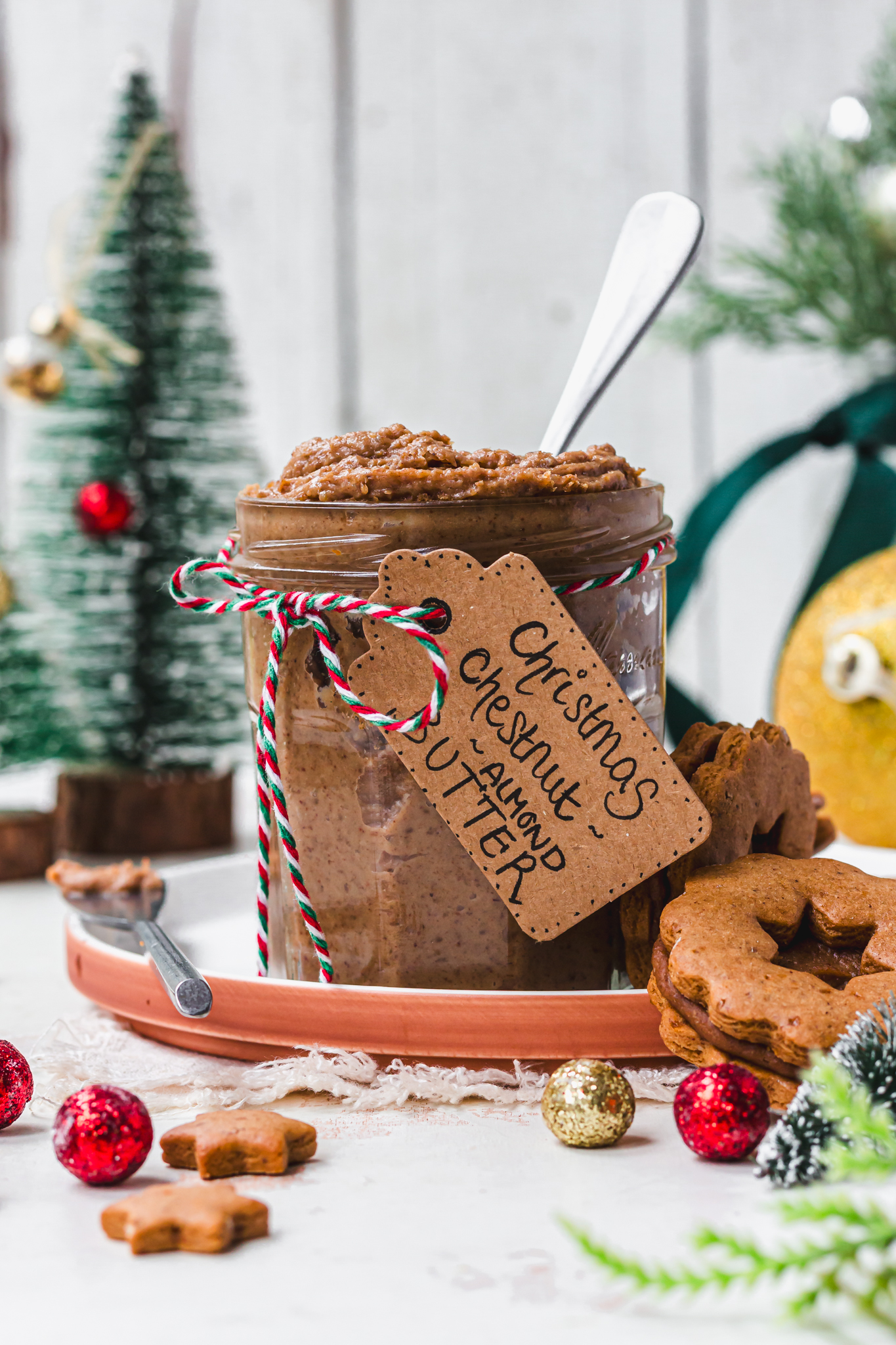 A jar of Christmas Chestnut Almond Butter with a spoon