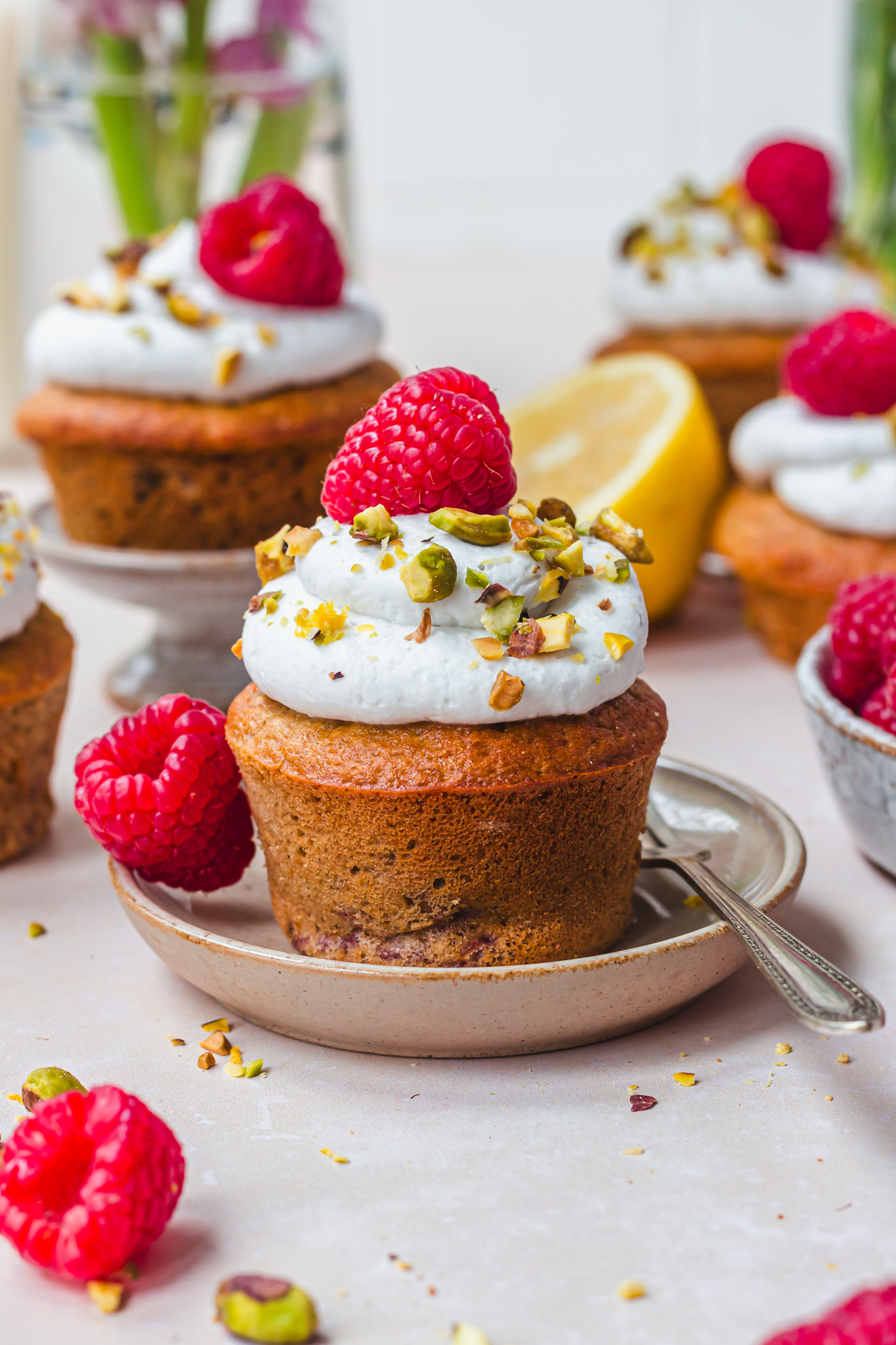 A Lemon Raspberry and Pistachio Muffin on a small plate