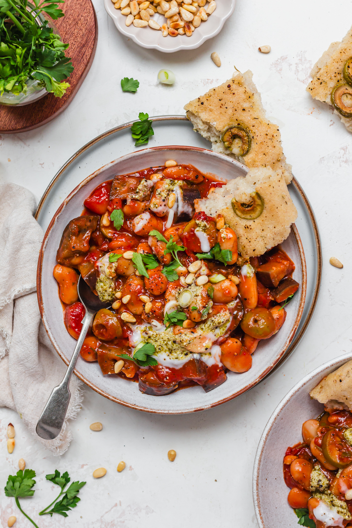 A bowl of Caponata Aubergine Butterbeans with a spoon