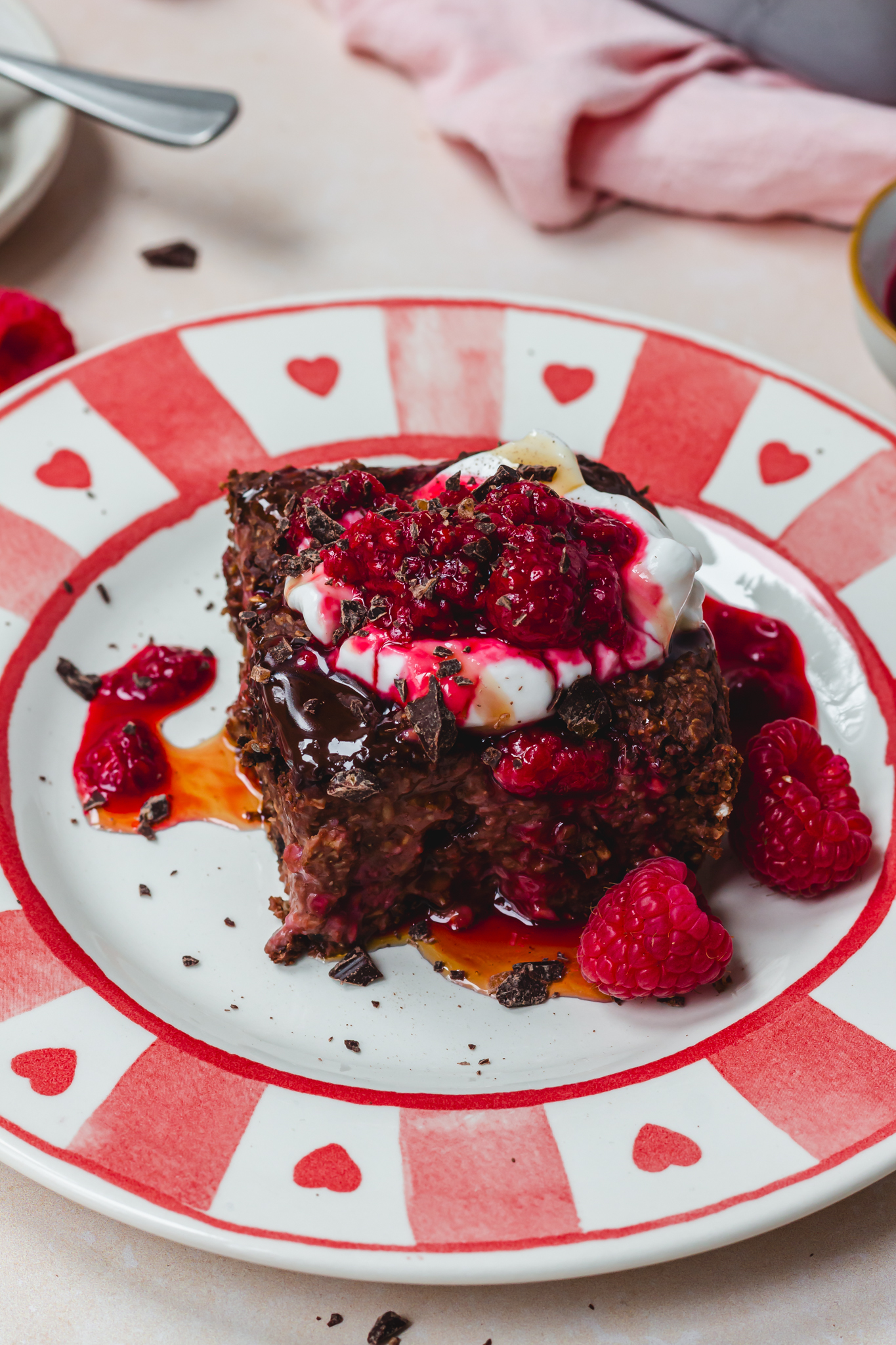 A piece of Chocolate Raspberry Baked Protein Oats with yoghurt and berries