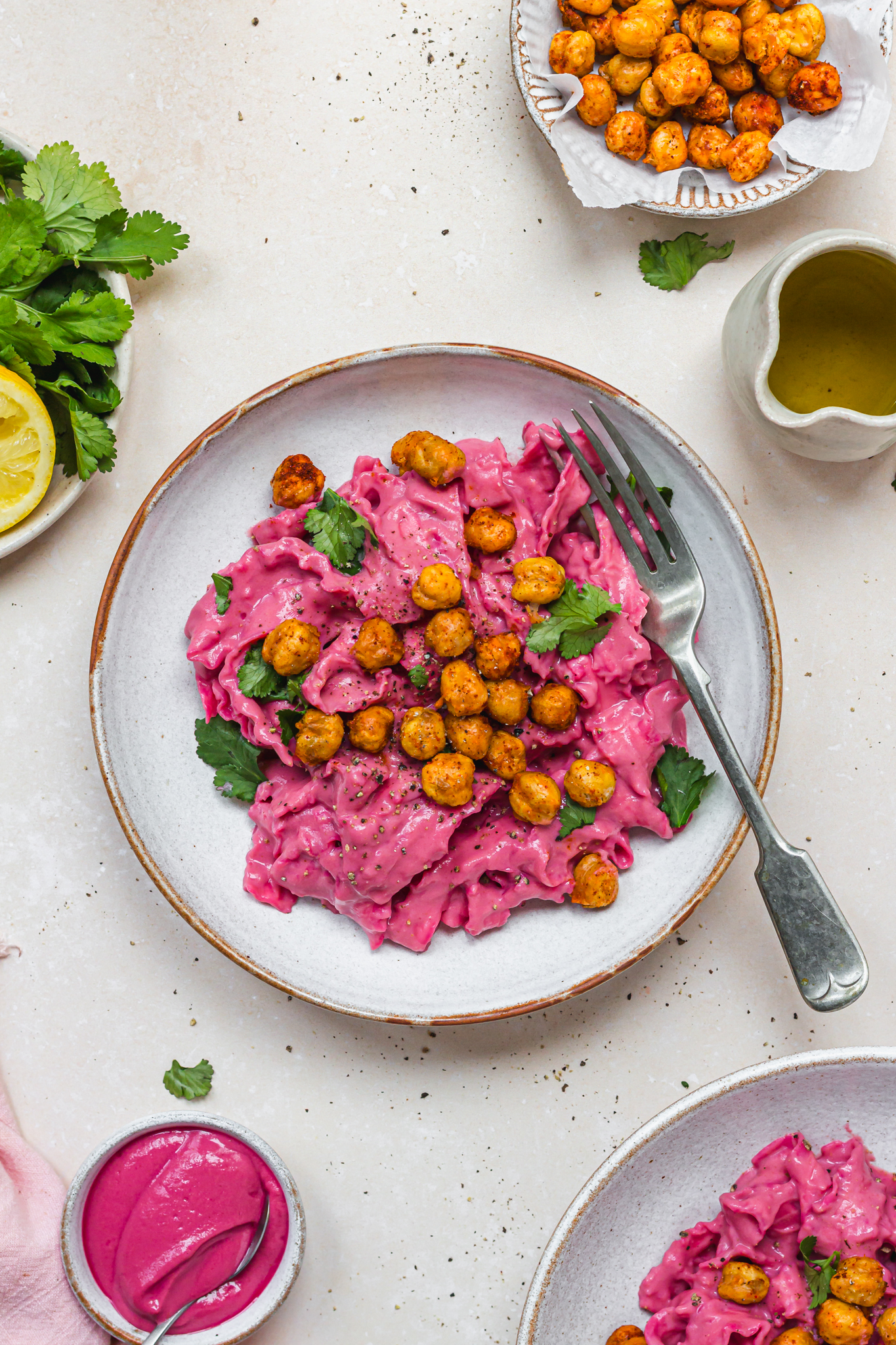 A bowl of Creamy Beetroot Pasta with Crispy Chickpeas with a fork