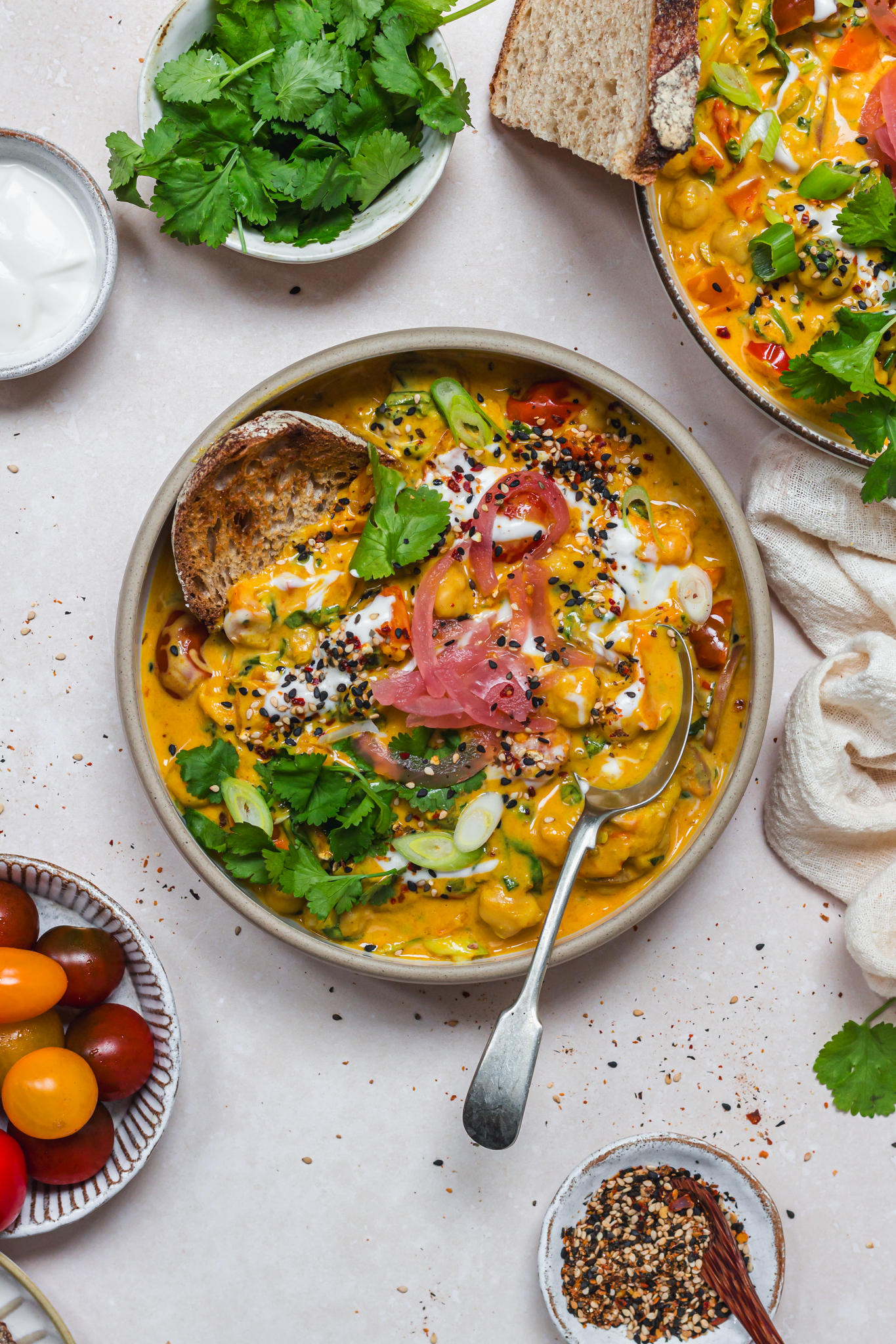 A bowl of Creamy Curried Chickpeas with Spinach with a spoon