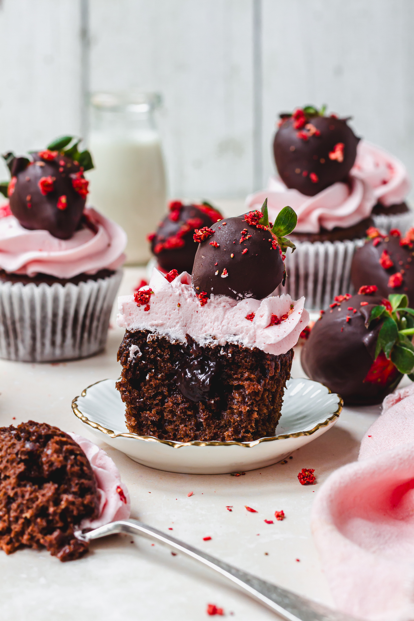 A half eaten Chocolate Strawberry Fudge Cupcake