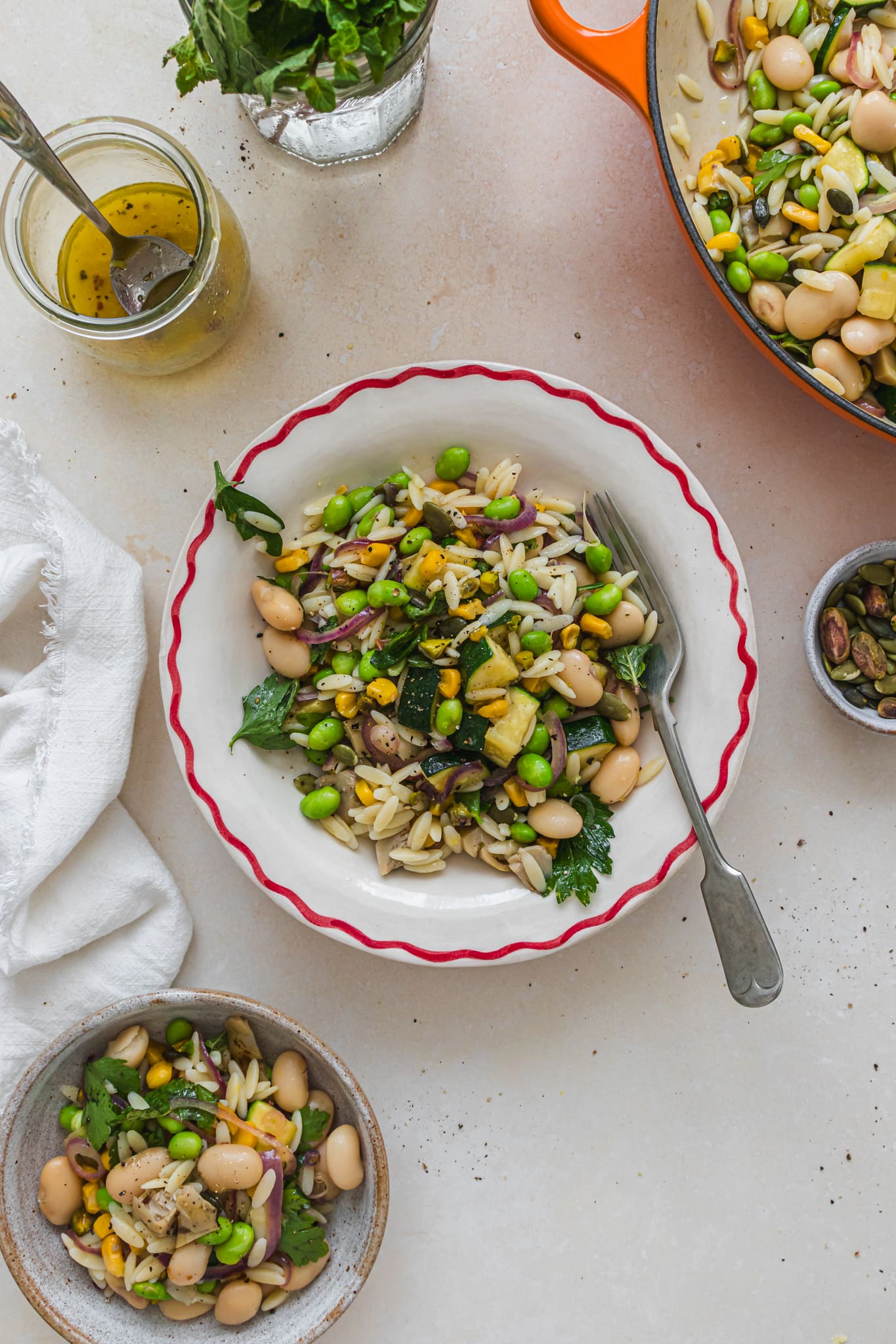 A bowl of Courgette Lemon and Butterbean Orzo Pasta Salad with a fork