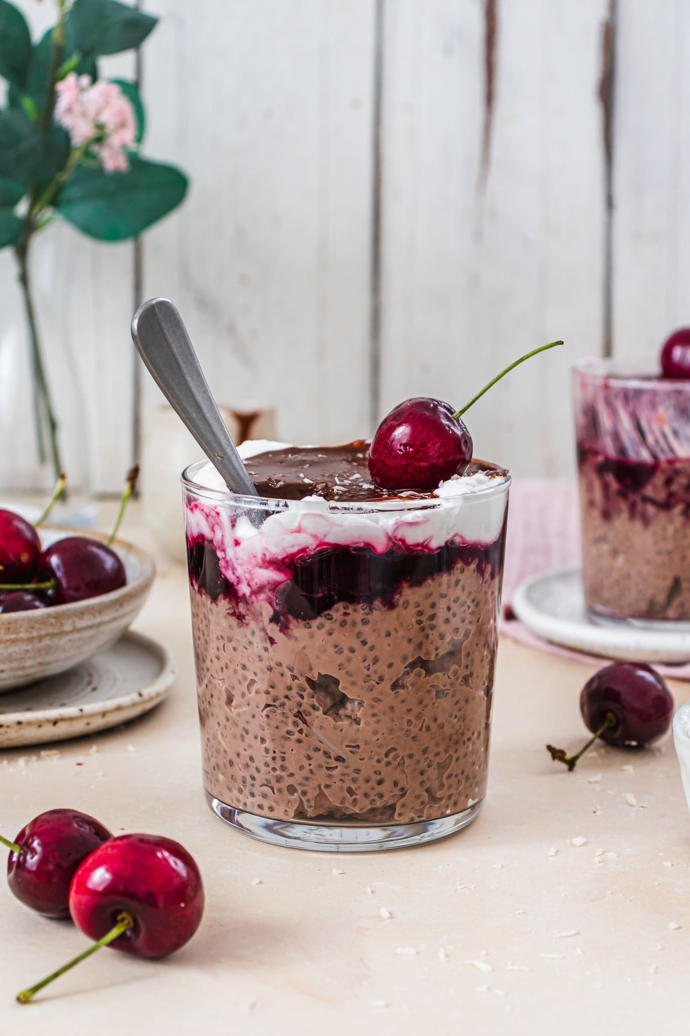 A jar of Chocolate Cherry Black Forest Chia Pudding with a spoon